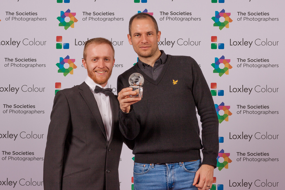 Adam being presented a trophy by The Societies of Photographers