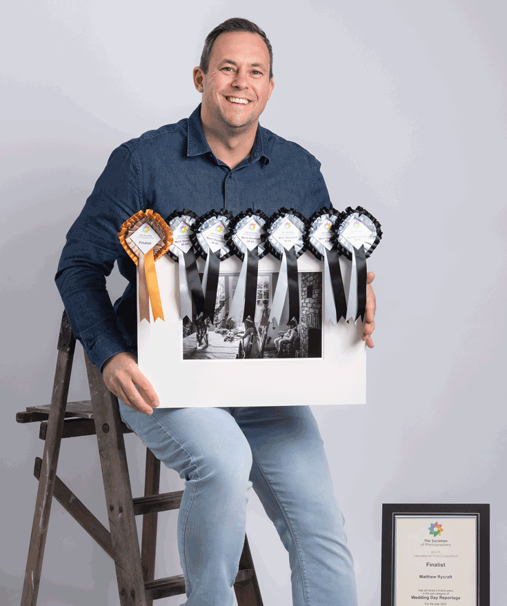 PermaJet Brand Ambassador, Matthew Rycraft, sat on stool holding a winning image and showcasing his rosettes and awards.