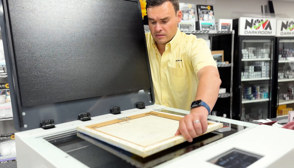 A PermaJet employee demonstrating scanning artwork on a WideTEK scanner